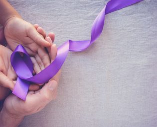 Hands holding Purple ribbons, toning copy space background, Alzheimer disease, Pancreatic cancer, Epilepsy awareness, domestic violence wareness